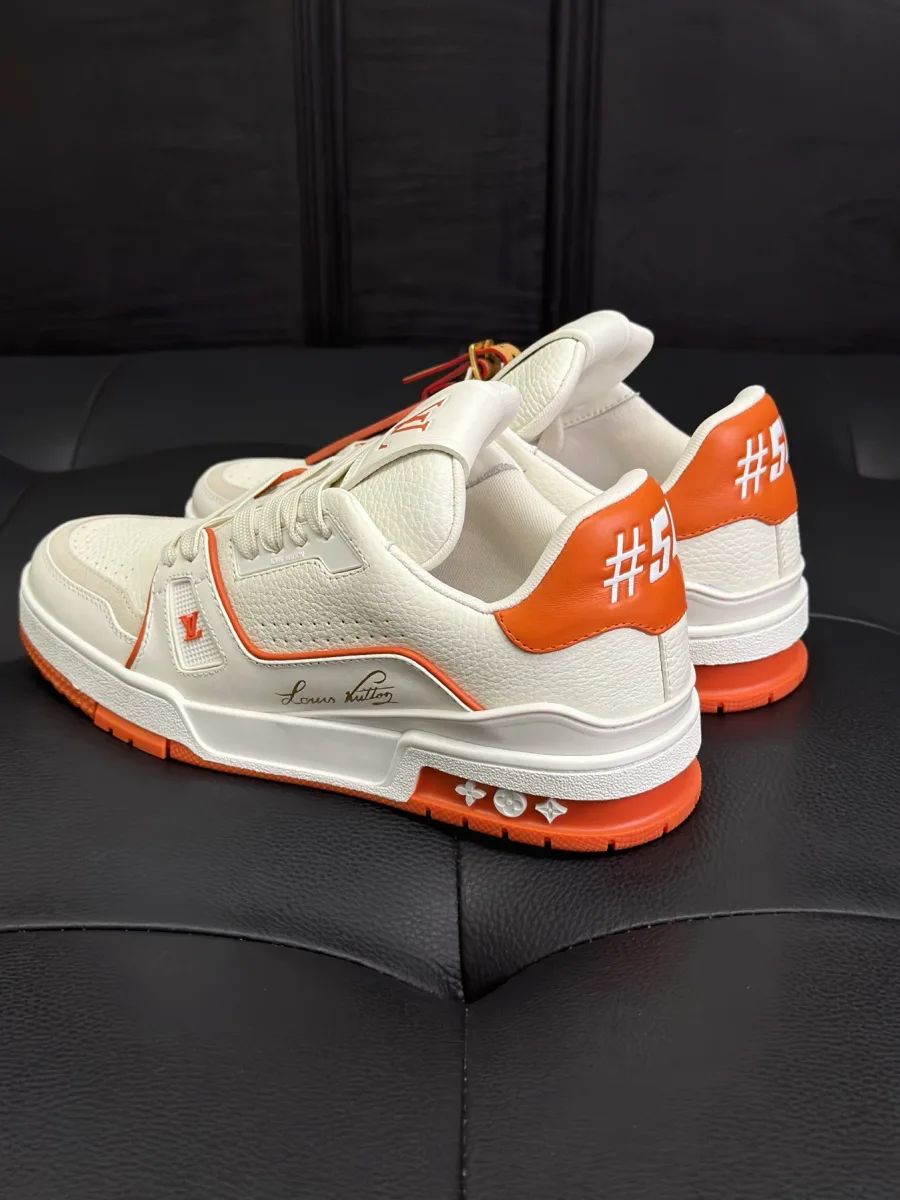 Бело-оранжевые кроссовки LV Trainer, ракурс три четверти сзади на задники с логотипом #54