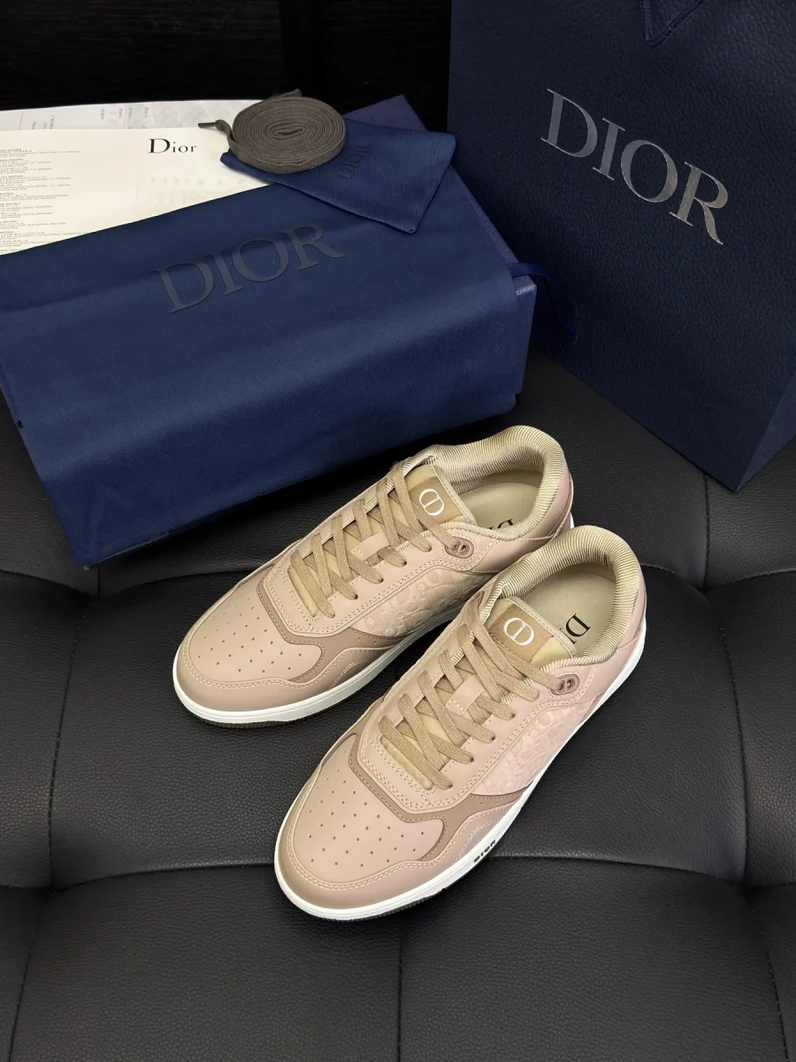 Бежевые низкие кеды Dior B27 рядом с фирменной синей коробкой и пакетом