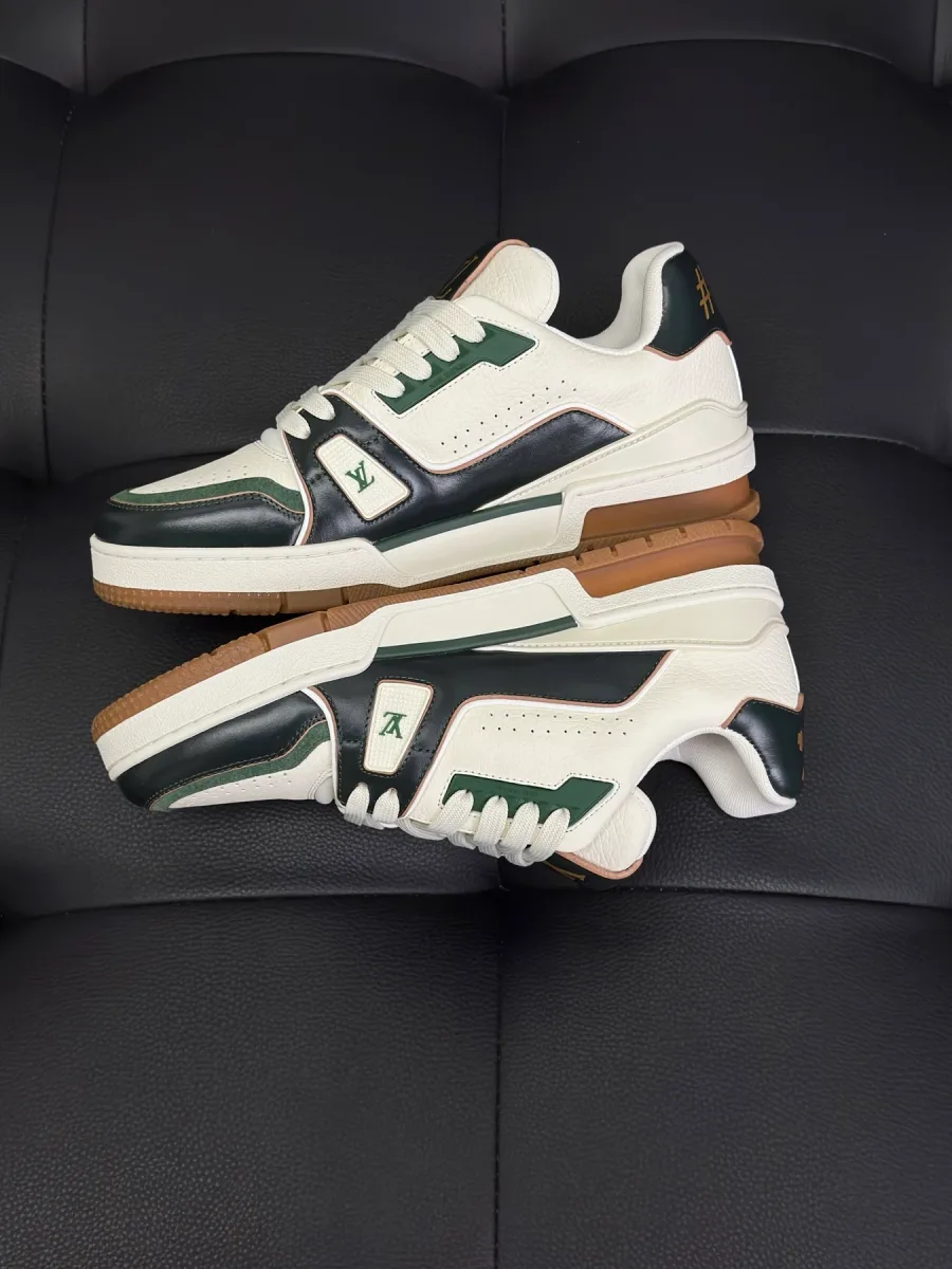 Пара кроссовок LV Trainer с зелёными панелями, вид сбоку и на подошву