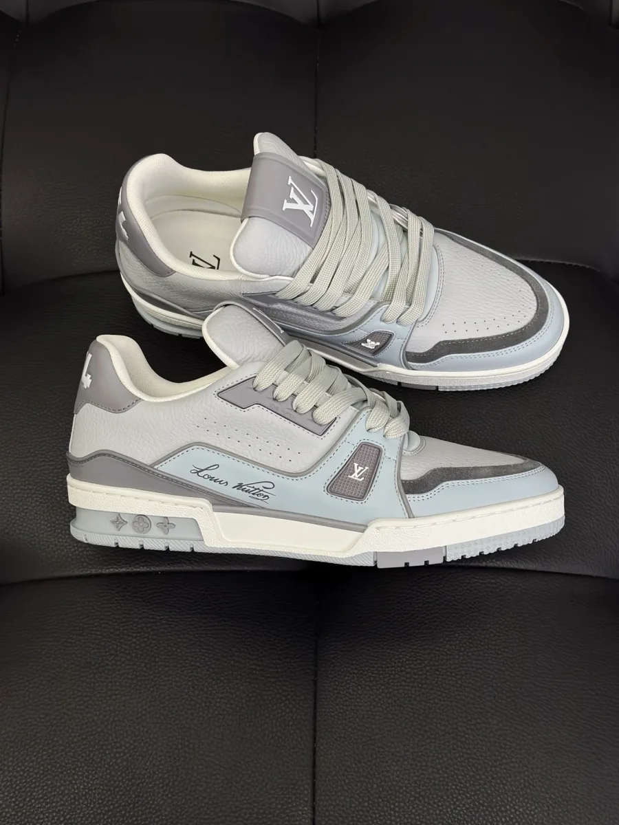 Пара серо-белых кожаных кроссовок LV Trainer с бокового ракурса