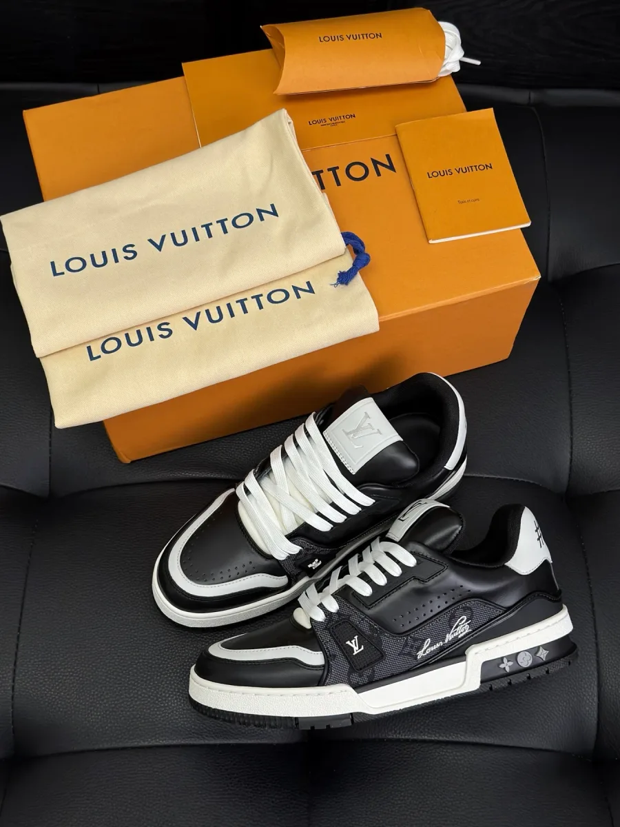 Чёрно-белые кроссовки LV Trainer рядом с фирменной коробкой и пыльниками