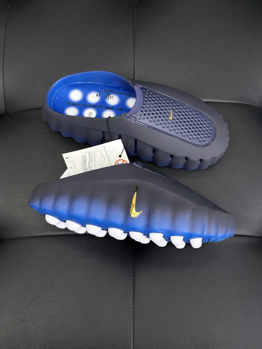 Боковой ракурс сабо с золотистым логотипом Swoosh и белыми элементами подошвы