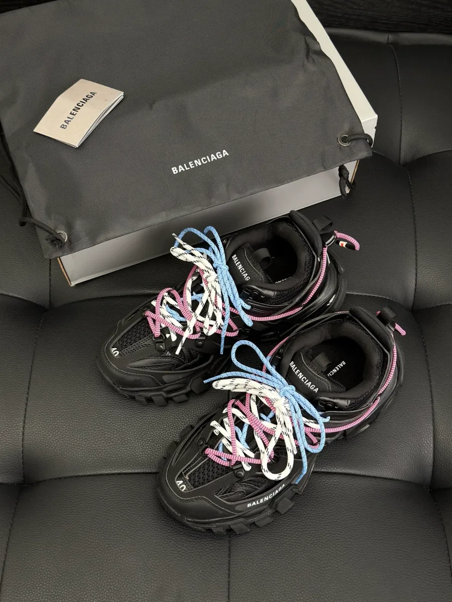 Чёрные кроссовки Balenciaga Track с разноцветными шнурками рядом с фирменной коробкой и пыльником