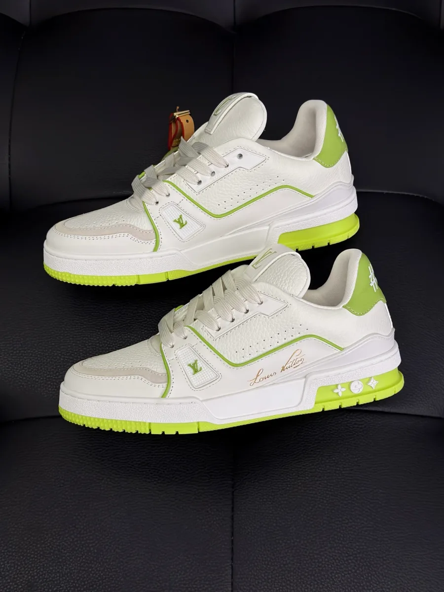 Пара кроссовок LV Trainer из зернистой кожи белого цвета с салатовыми деталями, вид сбоку