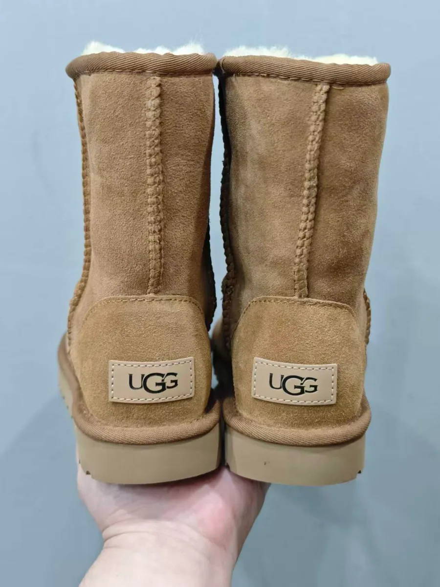 Задний вид пары бежевых сапог с текстильными накладками и маркировкой UGG