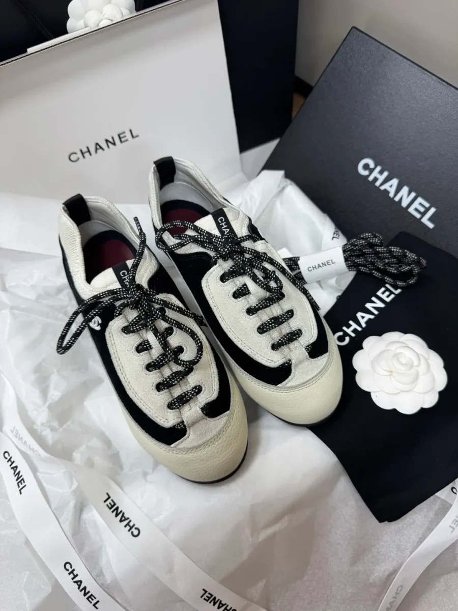 Чёрно-белые кроссовки Chanel в фирменной коробке с пыльником и цветком камелии, вид сверху