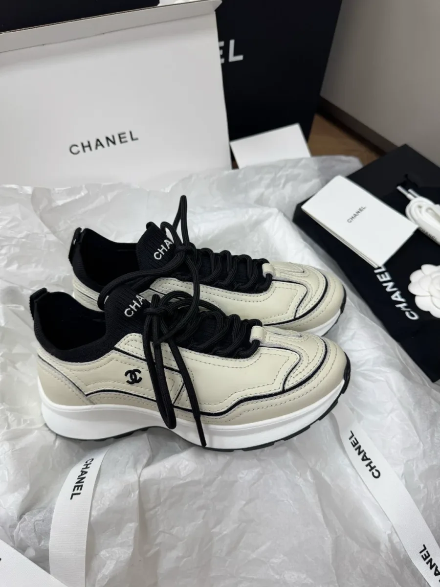 Бежево-чёрные женские кроссовки Chanel, вид сбоку на упаковочной бумаге