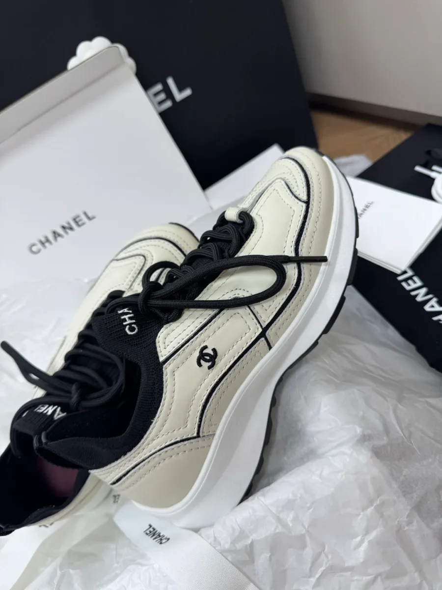 Кроссовки Chanel в ракурсе три четверти на фоне фирменной коробки