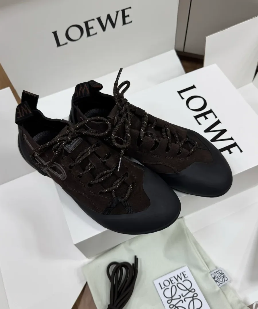 Пара тёмно-коричневых замшевых кроссовок Loewe Grip на фоне фирменной коробки, вид сверху и сбоку