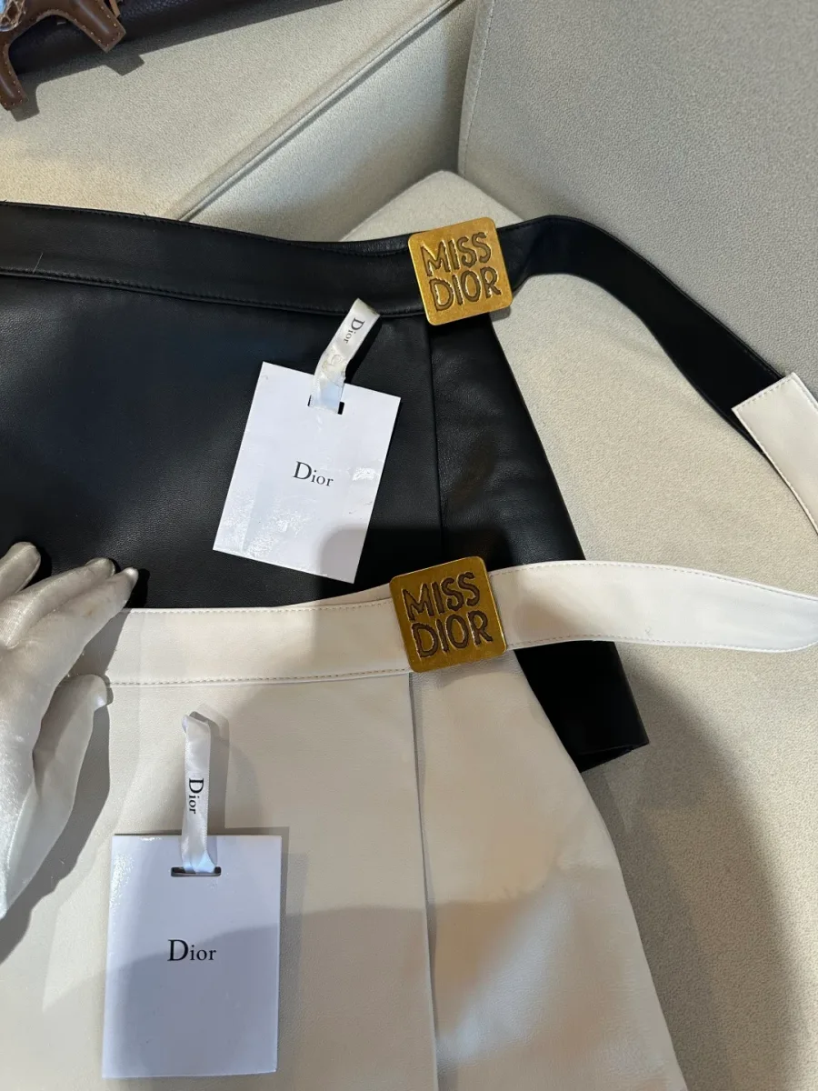Крупный план пояса с золотистой пряжкой с тиснением Miss Dior