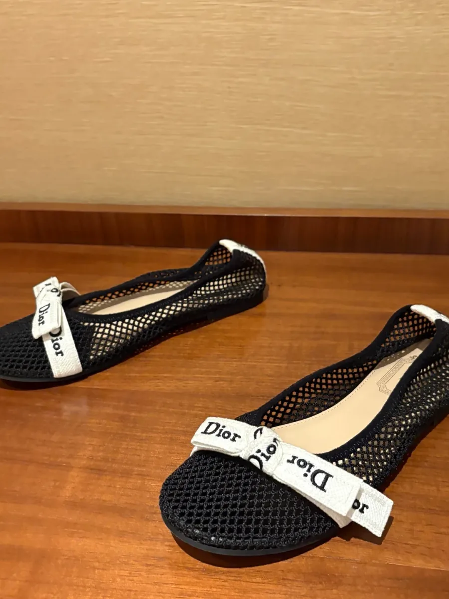 Чёрные балетки Dior из сетчатого текстиля на деревянной поверхности
