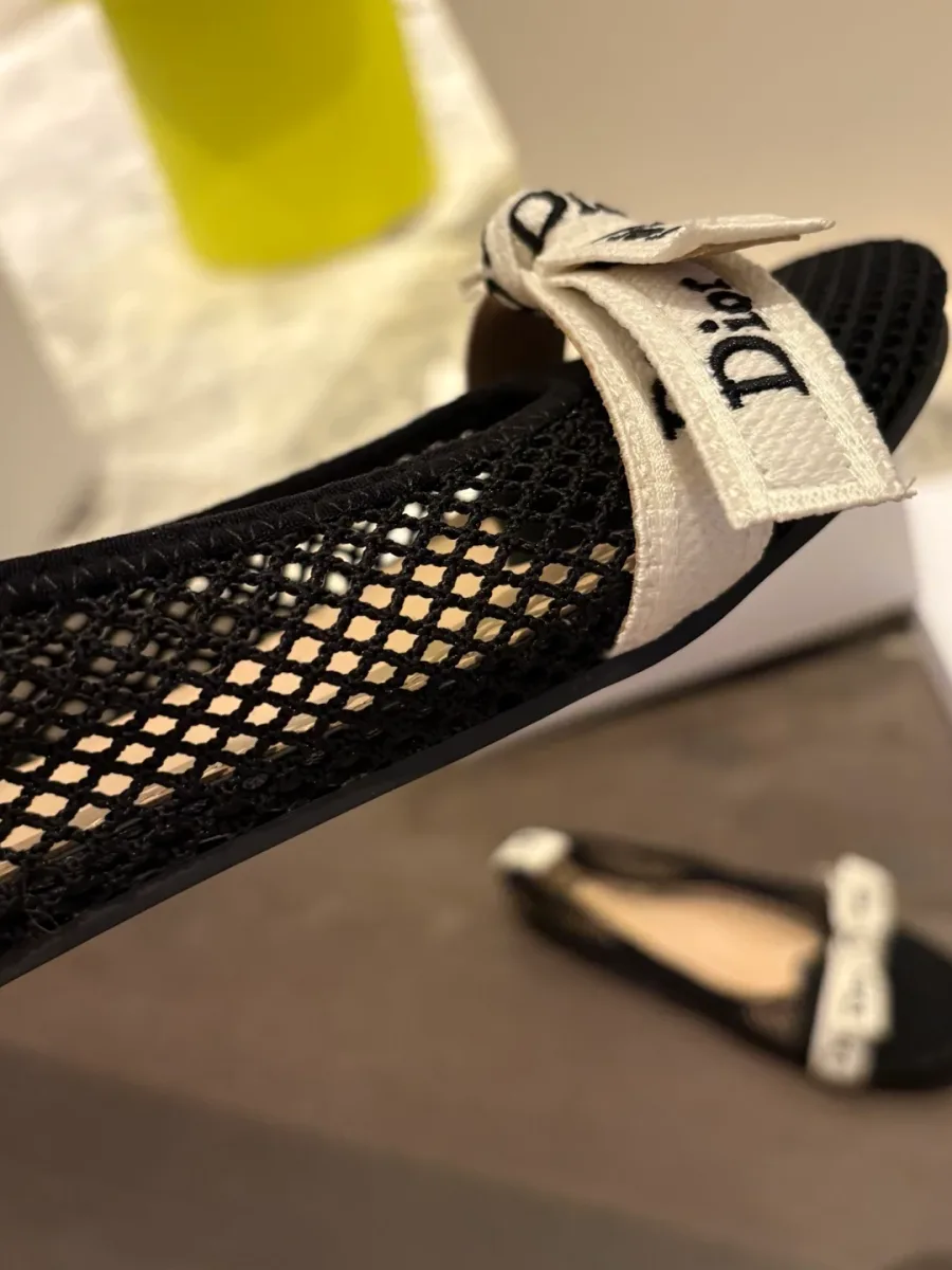 Боковая часть чёрной балетки Dior с бантом и фактурной сеткой вблизи