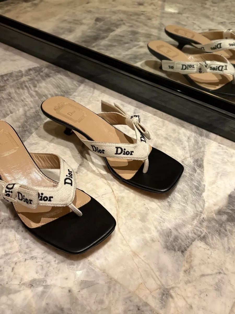 Пара шлёпанцев Dior на каблуке на зеркальной поверхности, вид сверху