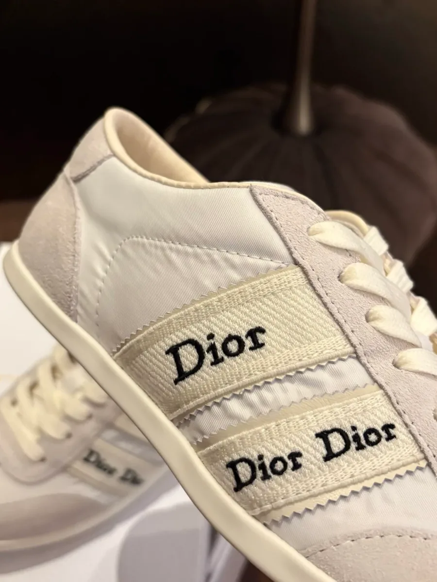 Крупный план боковой стороны кроссовка с жаккардовыми лентами и вышивкой Dior