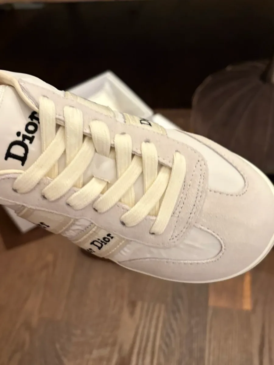 Вид сверху на шнуровку, фигурный замшевый мысок и язычок с надписью Dior