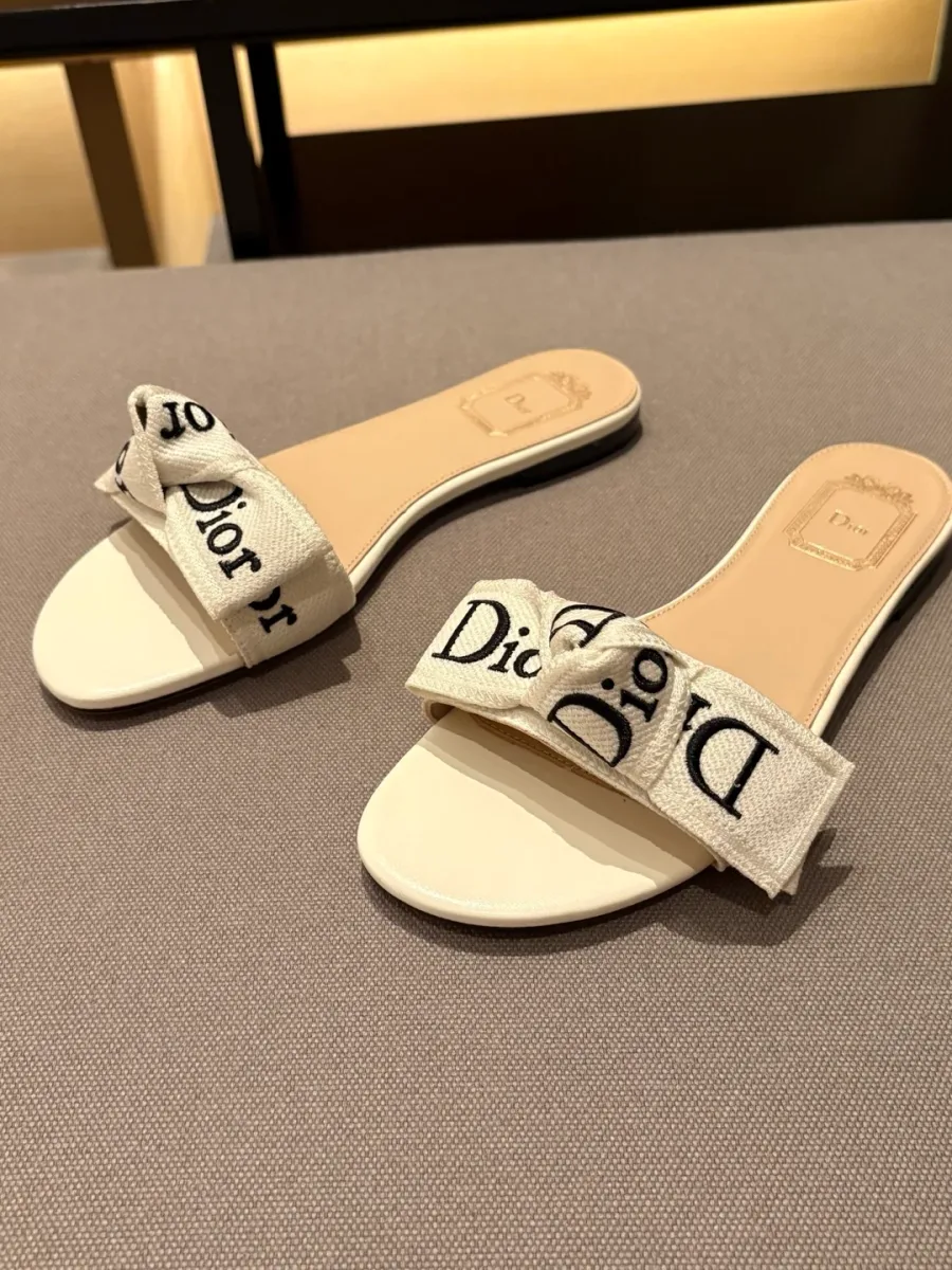 Белые шлёпанцы Dior с текстильным бантом и надписью J'Adior на серой ткани
