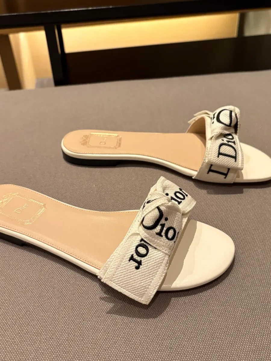Шлёпанцы Dior с бантом и вышивкой, вид сбоку на сером фоне