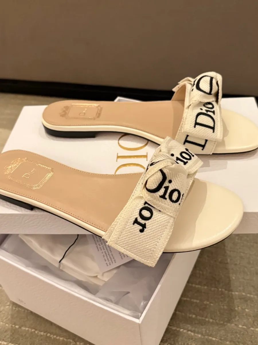 Пара белых шлёпанцев Dior на фирменной белой коробке бренда