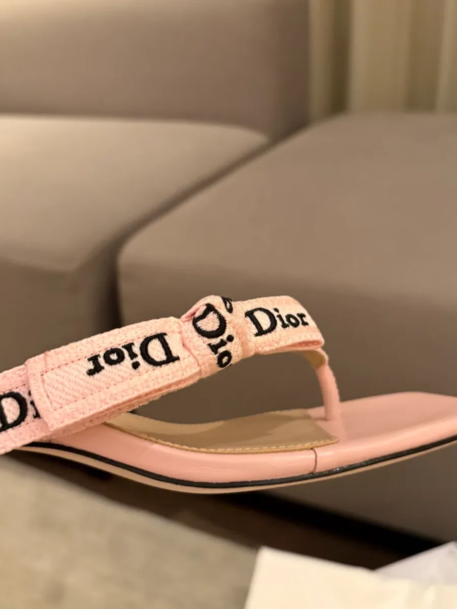Текстильный ремешок через палец с вышитой надписью Dior и бантом, вид сбоку крупным планом