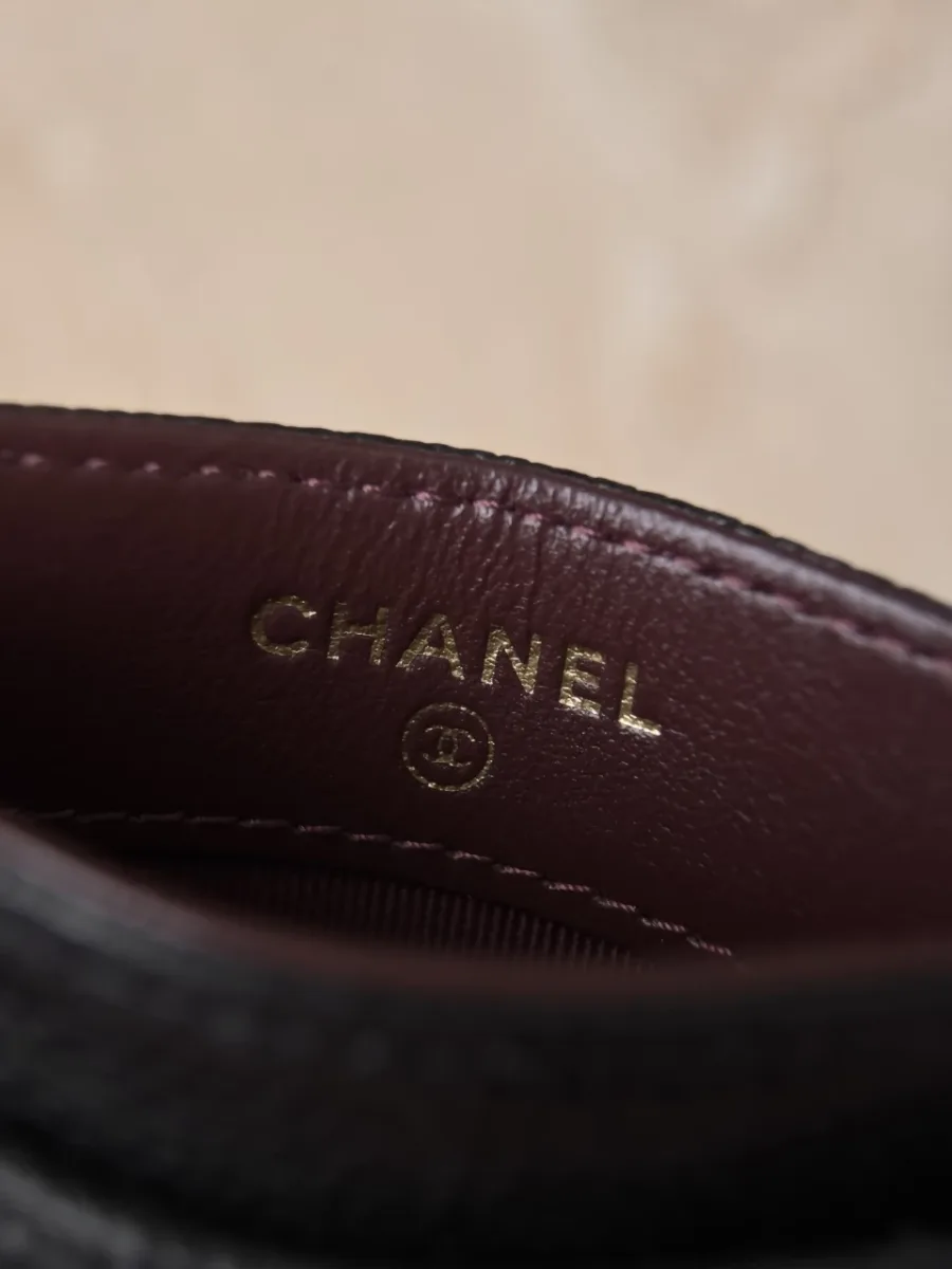Золотистое тиснение Chanel на бордовой кожаной подкладке