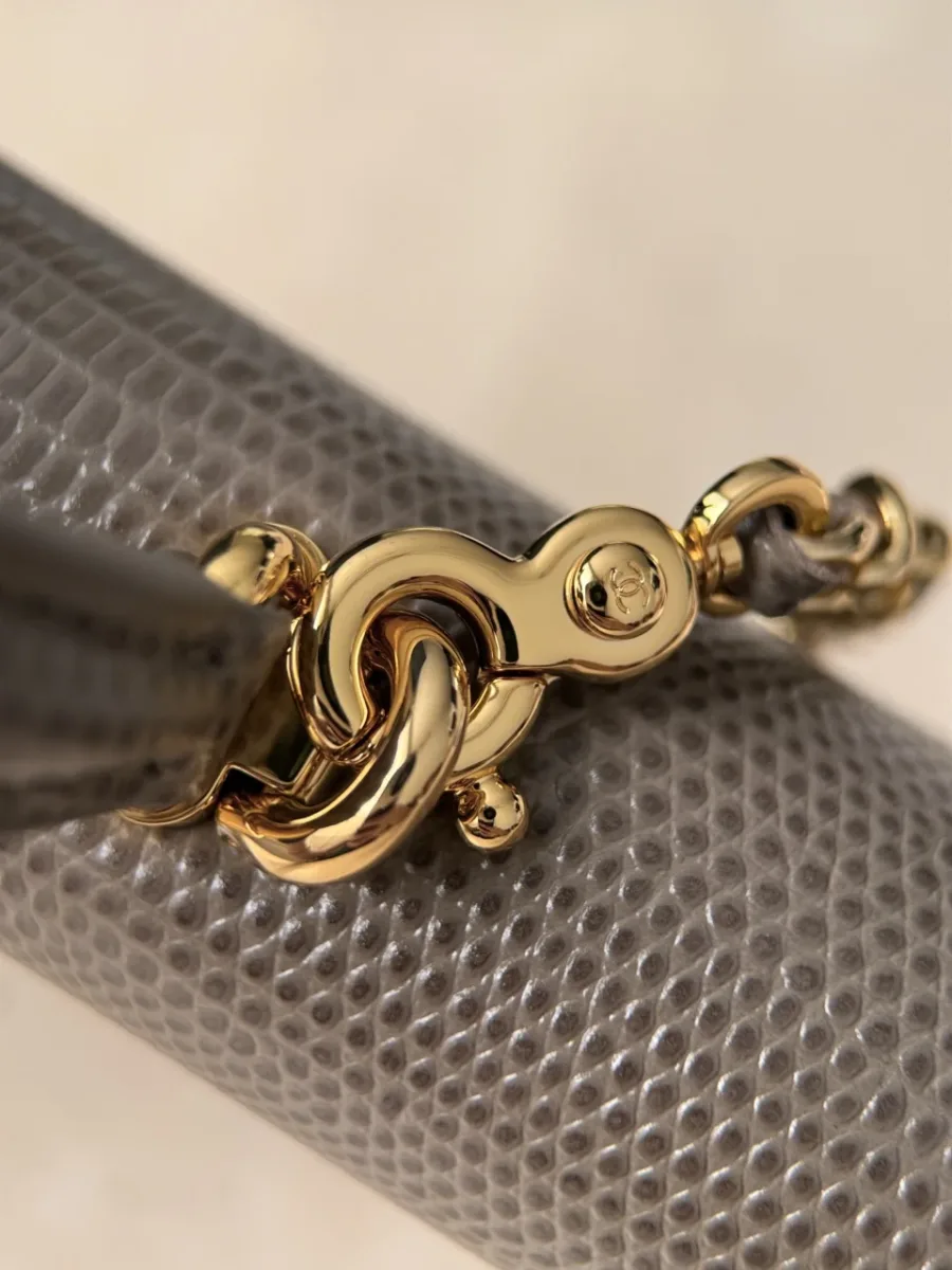 Деталь золотистого карабина и цепочки бежевой сумки Chanel
