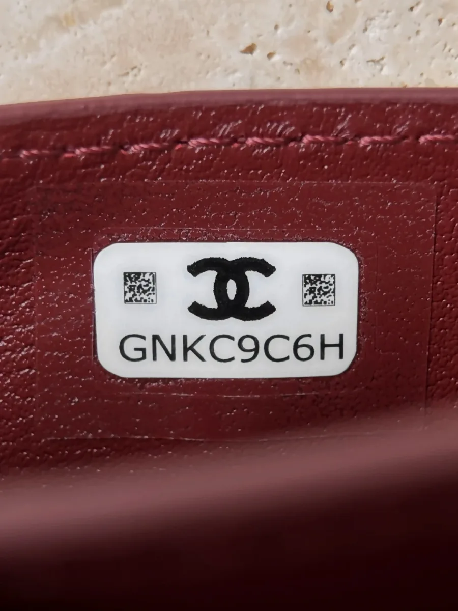 Крупный план белой наклейки с серийным номером GNKC9C6H внутри картхолдера