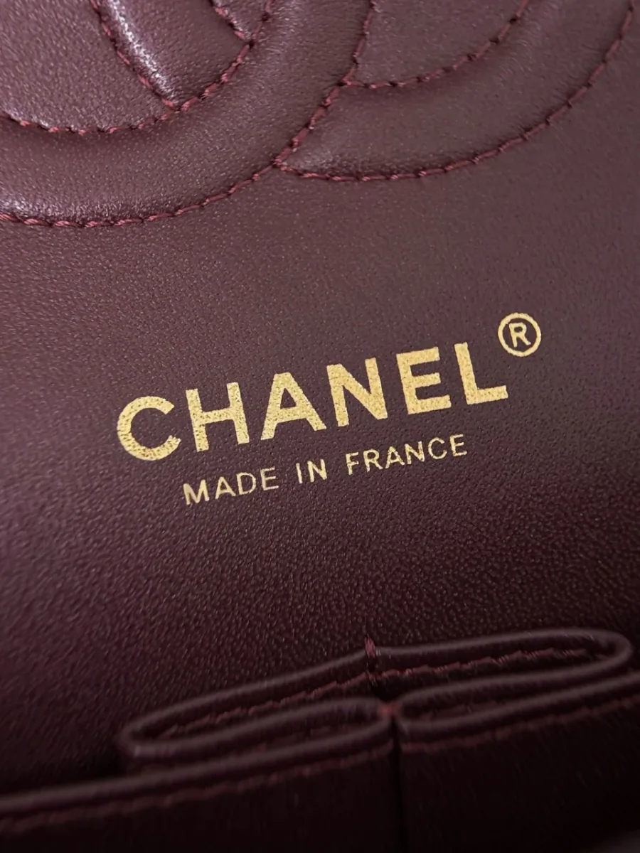 Золотистое тиснение Chanel Made in France на бордовой коже