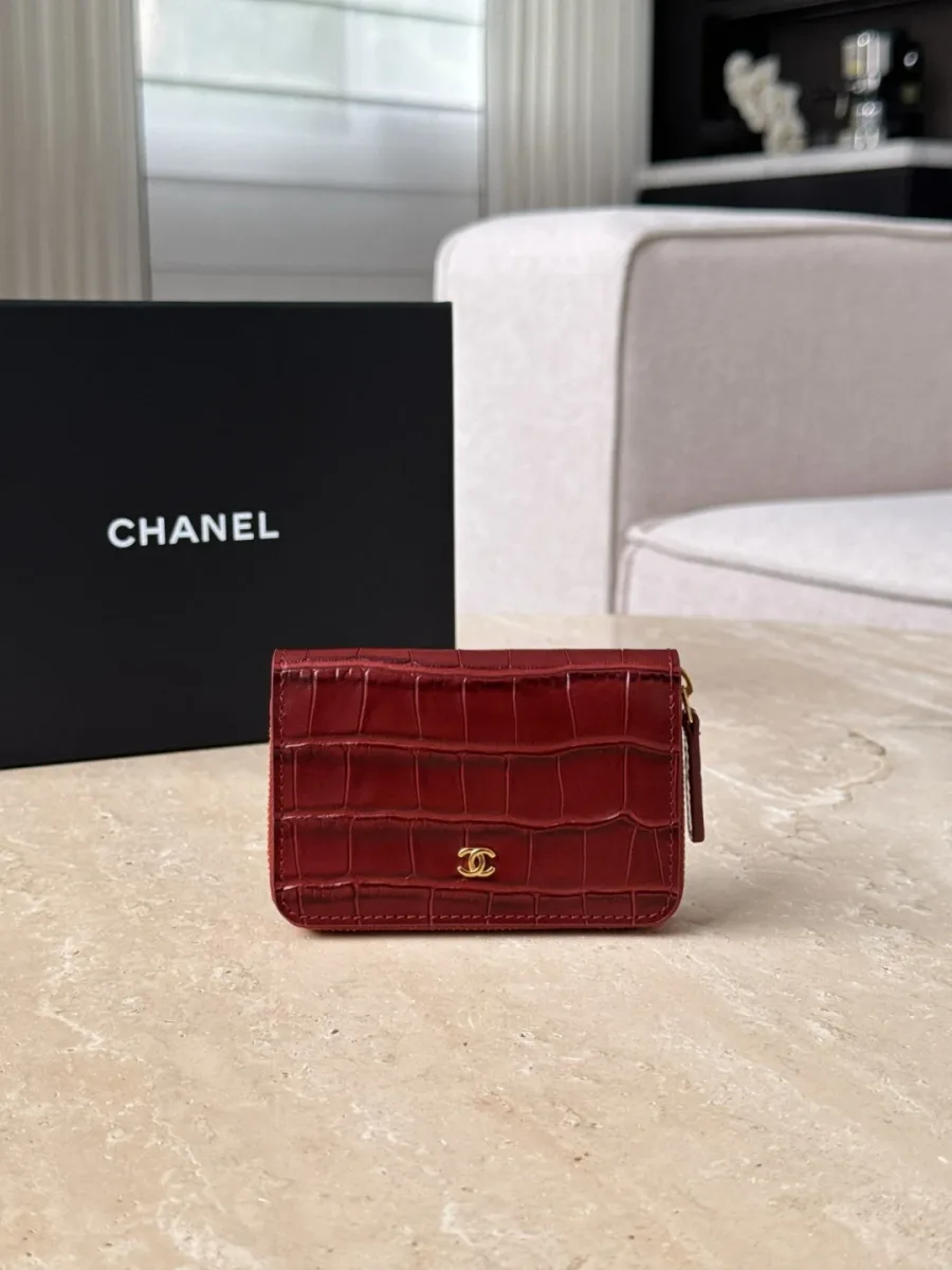 Бордовый картхолдер Chanel с тиснением под крокодила на фоне коробки, вид спереди