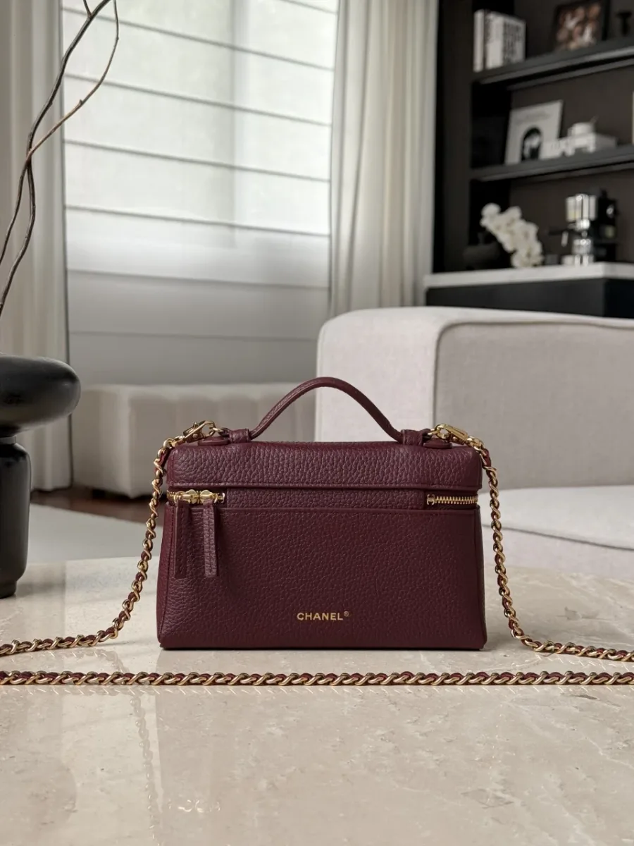 Задняя сторона бордовой сумки Chanel Vanity Case с золотистым тиснением бренда
