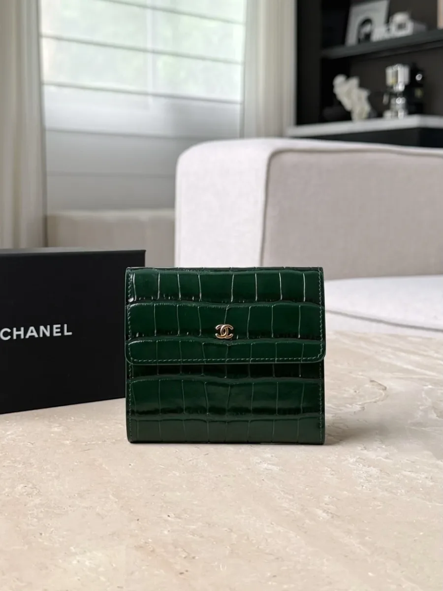 Зеленый трехскладной кошелек Chanel с тиснением под крокодила, вид спереди на фоне коробки