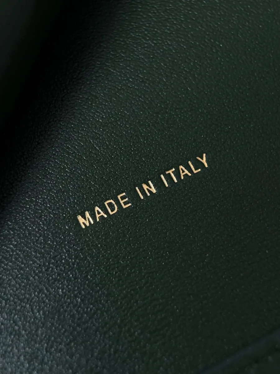 Крупный план золотистого тиснения Made in Italy на зеленой коже