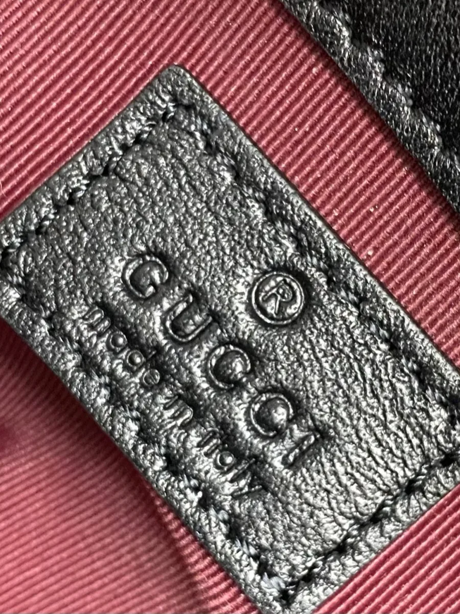 Тиснение логотипа Gucci Made in Italy на внутреннем кожаном ярлыке крупным планом