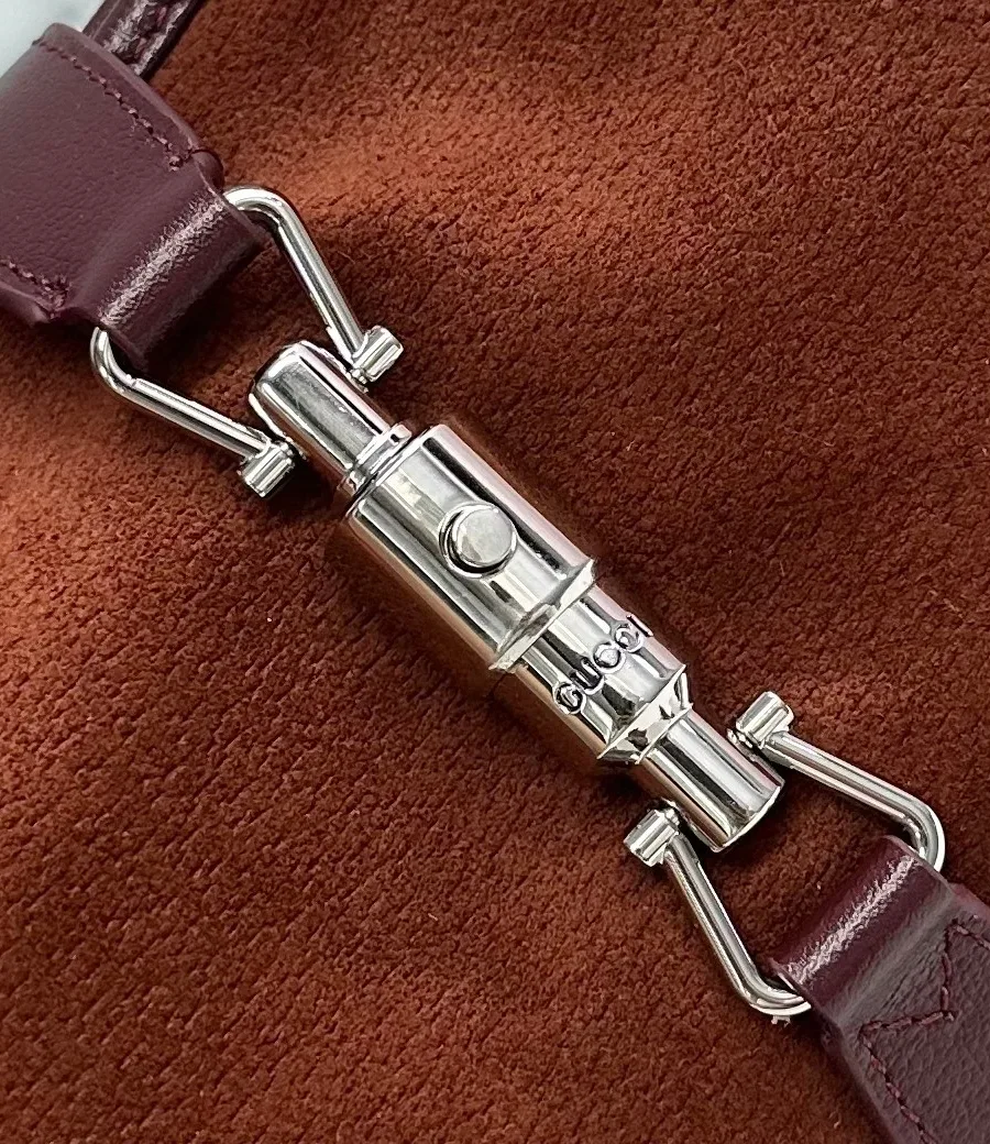 Серебристый замок-поршень push-lock на замшевой сумке Gucci Jackie 1961