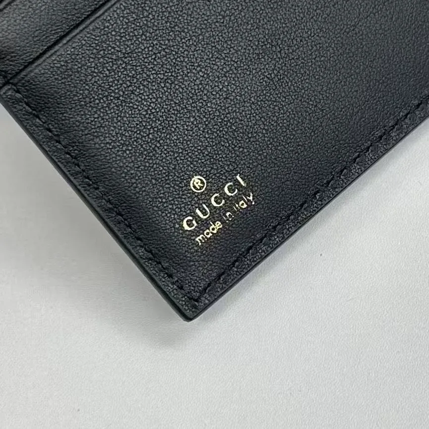 Тиснение золотистого логотипа Gucci made in Italy на черной коже