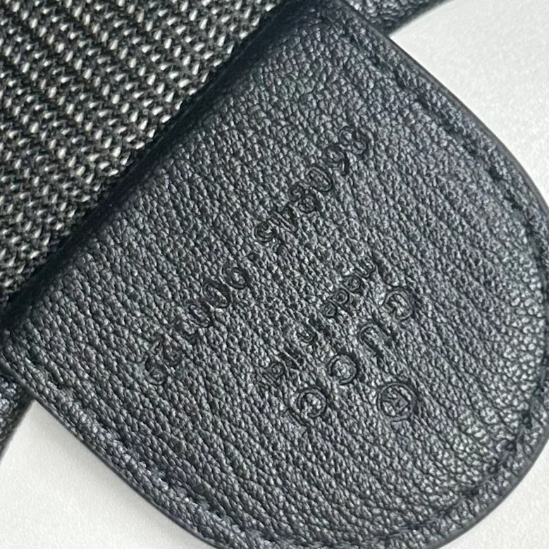 Кожаный элемент с чётким тиснением Gucci Made in Italy и серийным номером крупным планом
