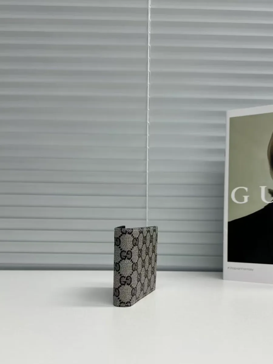Кошелёк двойного сложения Gucci с узором GG в профиль на светлом столе