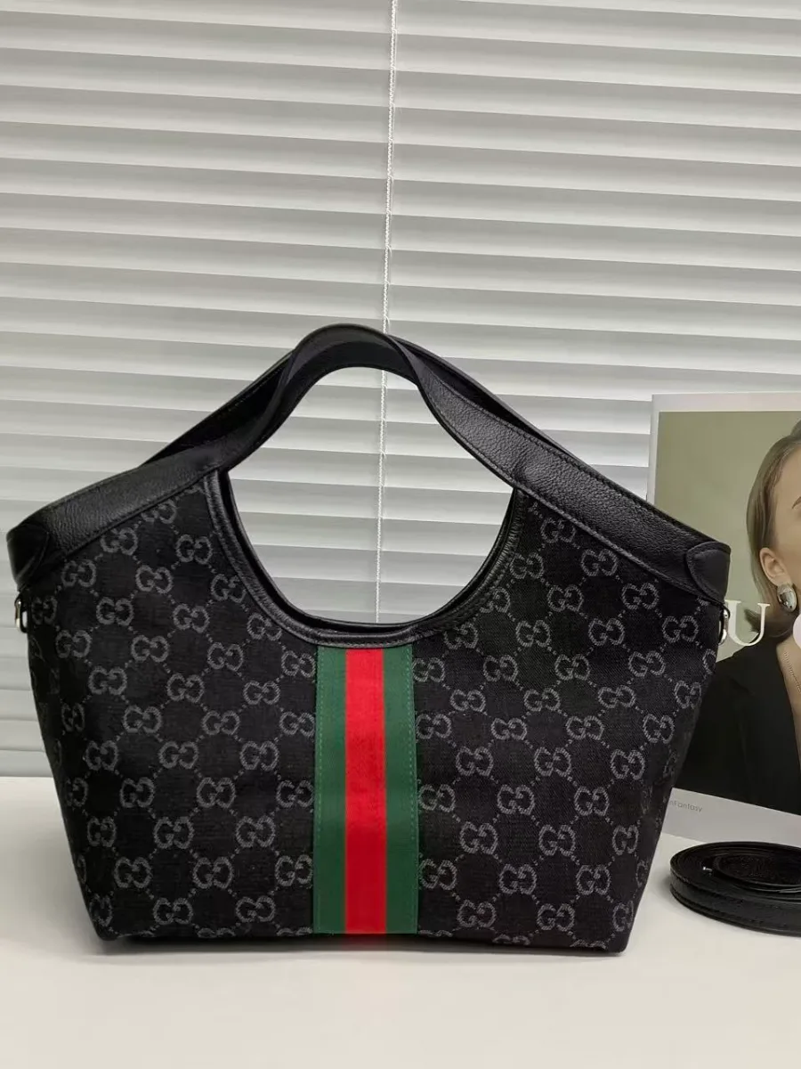 Задняя сторона сумки Gucci Ophidia из чёрного канваса с узором GG и лентой Web