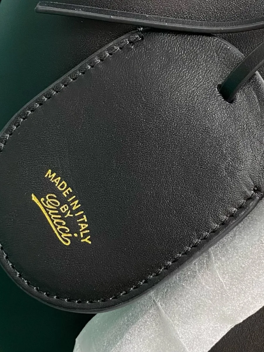 Кожаный брелок-тег чёрного цвета с золотистым тиснением Made in Italy by Gucci.