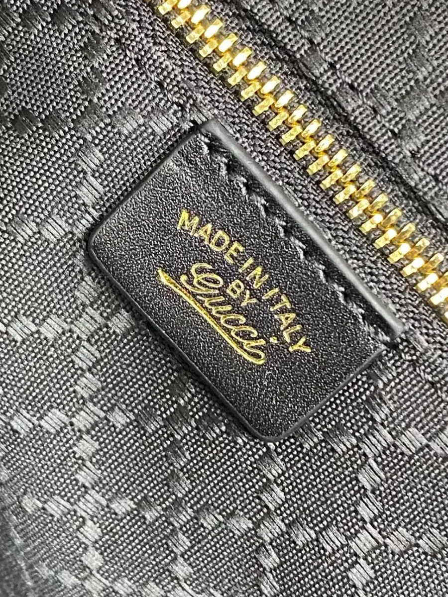 Кожаная внутренняя нашивка с золотистым тиснением Made in Italy by Gucci возле кармана на молнии.