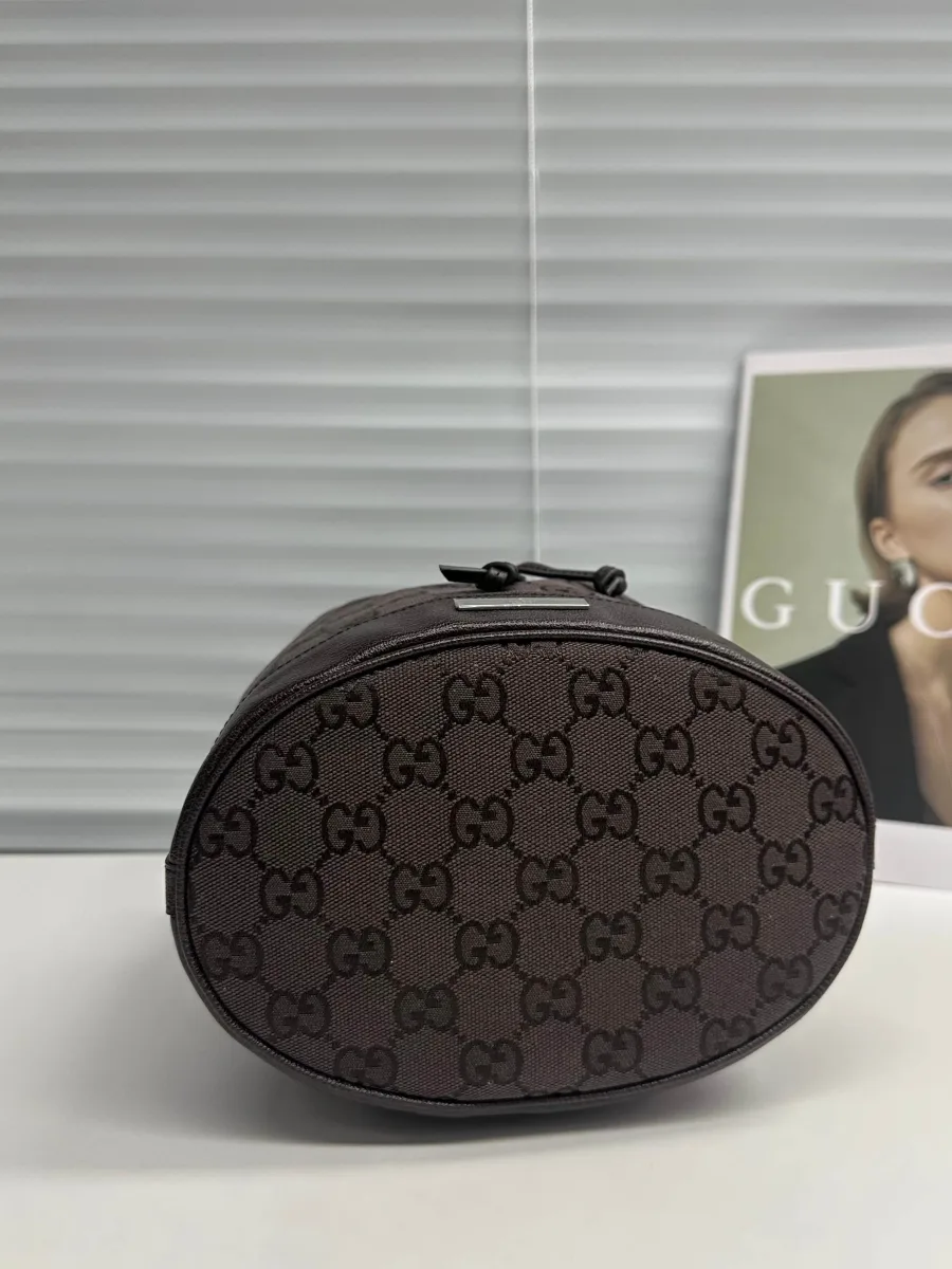 Овальное дно тёмно-коричневой сумки из канваса с узором GG