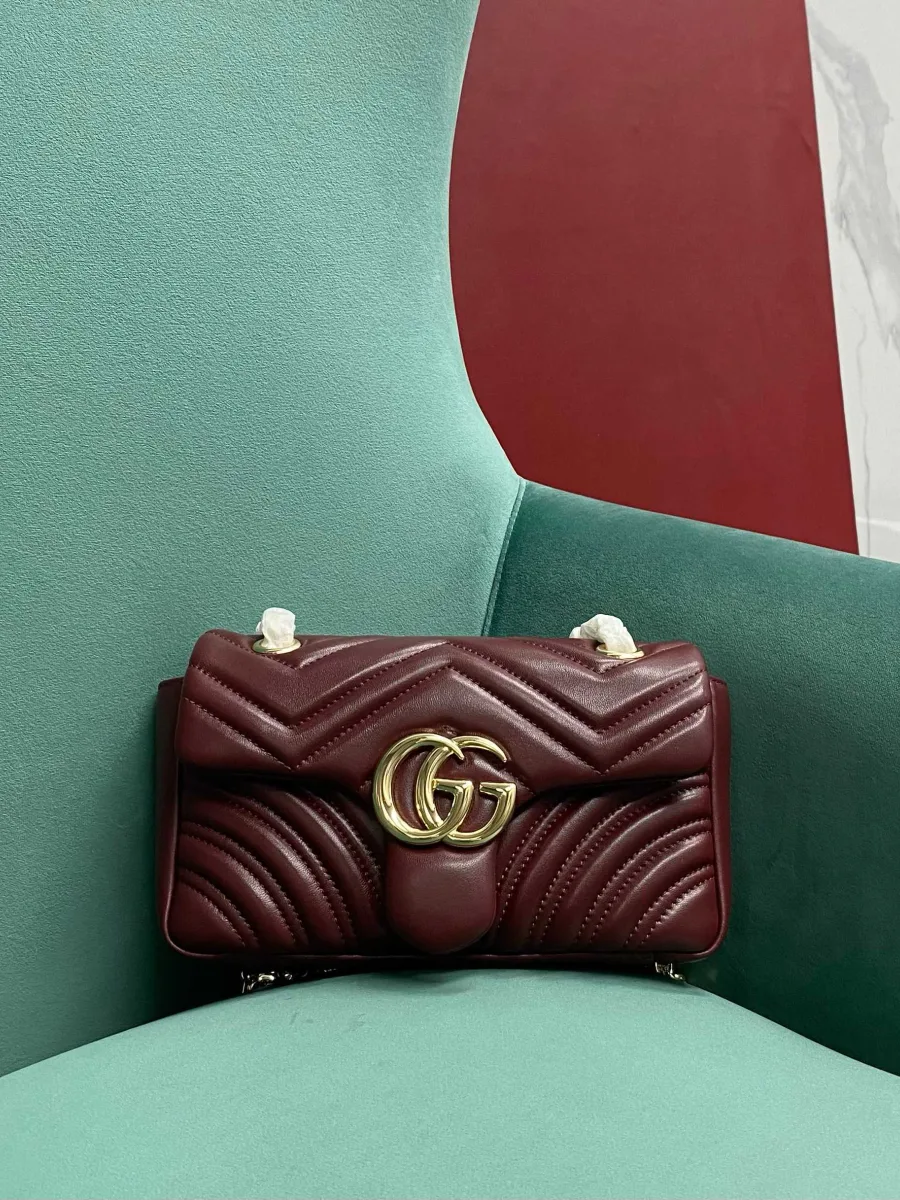 Бордовая стеганая сумка Gucci GG Marmont с золотистым логотипом, вид спереди
