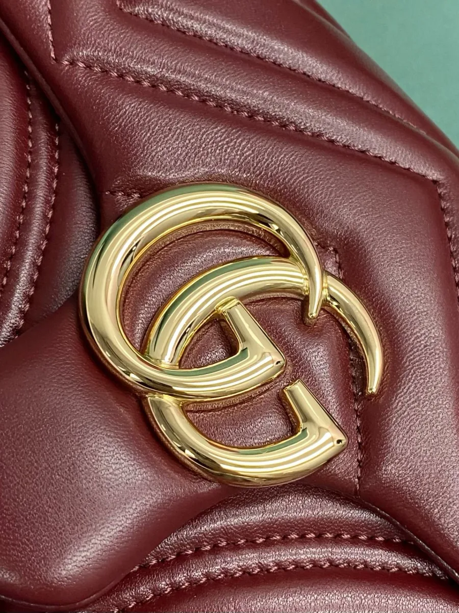 Золотистая металлическая монограмма Double G на стеганой бордовой коже сумки Gucci
