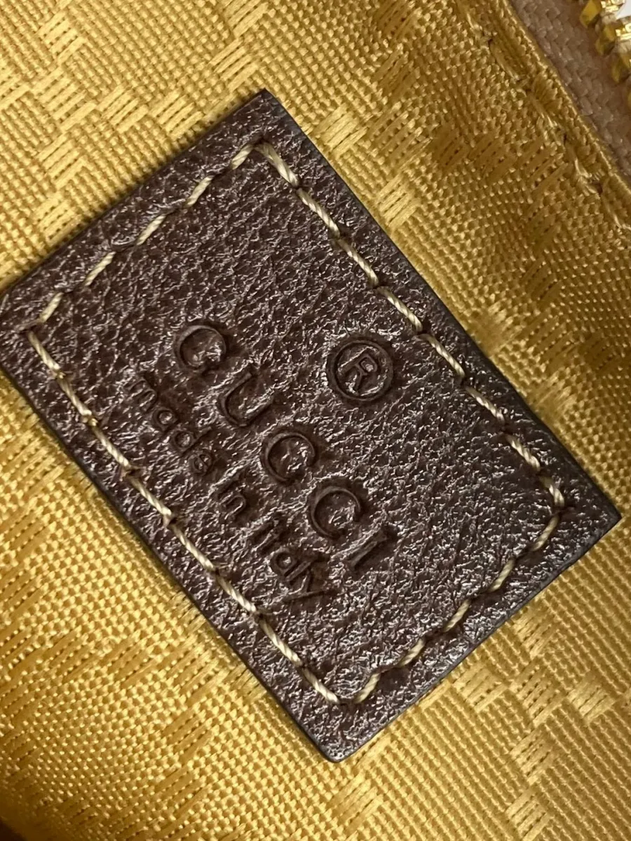 Кожаный ярлык с тиснением логотипа Gucci на фактурной подкладке