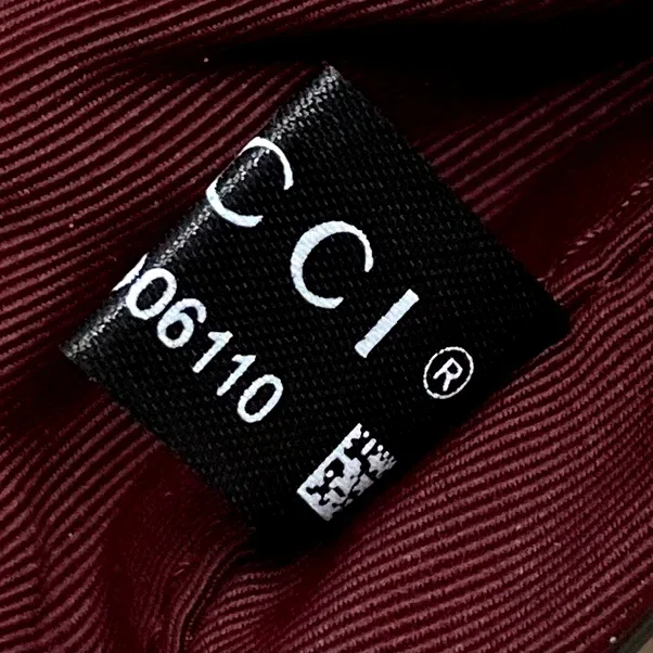 Бирка с логотипом Gucci внутри сумки на бордовой подкладке