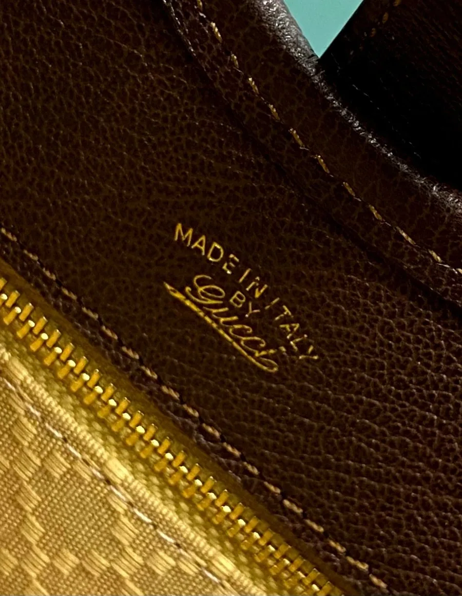 Золотистый штамп Made in Italy by Gucci над внутренним карманом на молнии