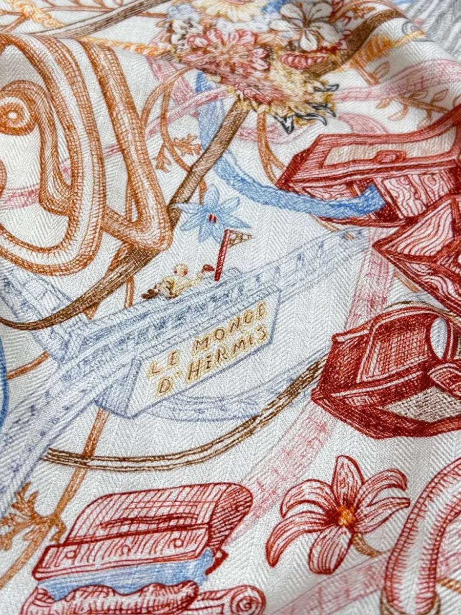 Фрагмент шали с цветной графикой и надписью Le Monde d'Hermes крупным планом