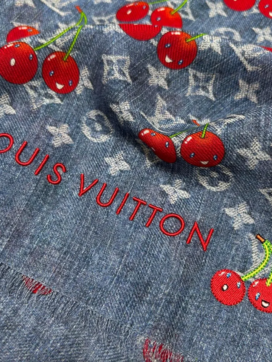 Крупный план жаккардового узора Monogram, вышитых вишен и надписи Louis Vuitton