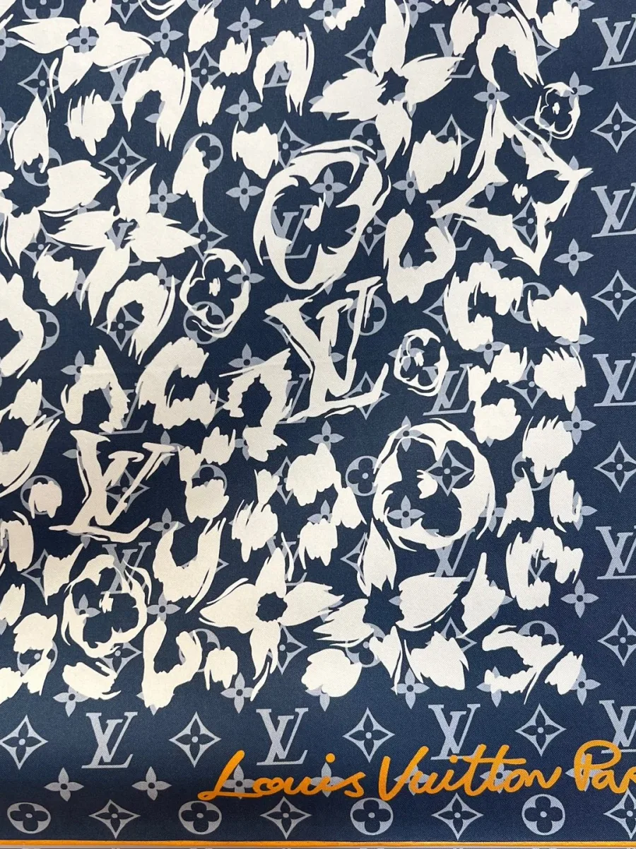 Крупный план сине-белого леопардового принта Monogram и надписи Louis Vuitton Paris