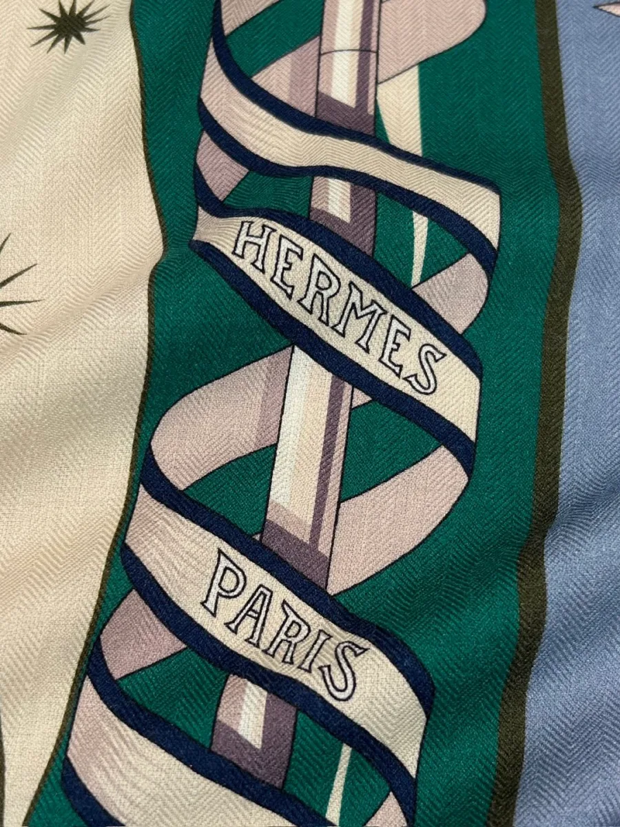 Крупный план шали Hermes с надписью Hermes Paris и деталями графического принта
