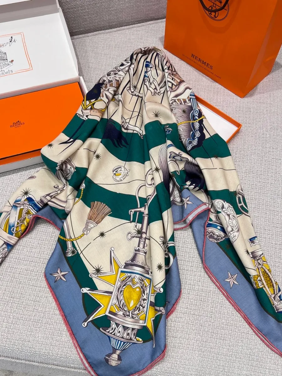 Драпированная шаль Hermes Chorus Stellarum на фоне оранжевой коробки и пакета